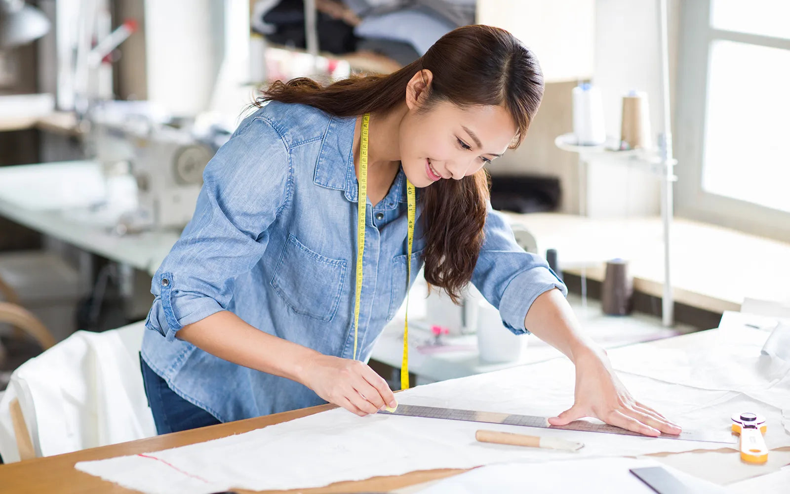 Woman measuring fabric in a sewing studio