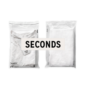 Front and back of a transparent Better Packaging POLLAST!C poly garment bag, containing a white tee shirt with a graphic label "Seconds" overlaid on a transparent background